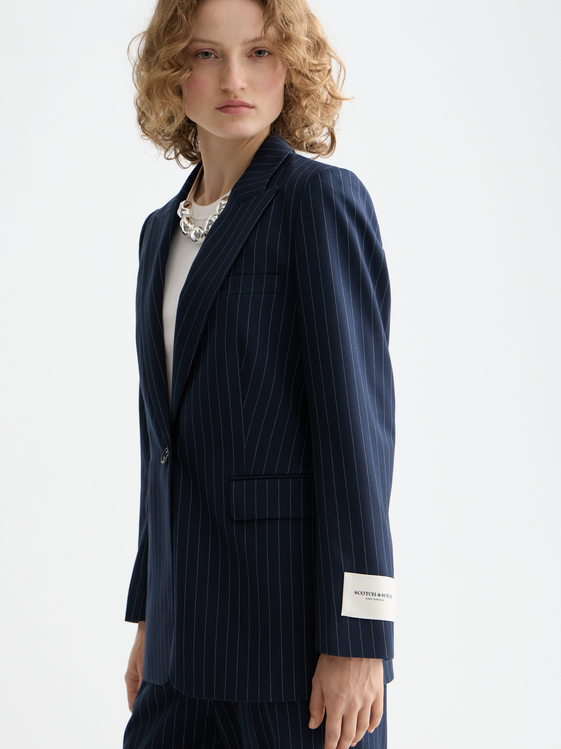 Fitted single-breasted blazer by Scotch & Soda, tailored cut, dark fabric, and classic lapel, displayed on a mannequin.