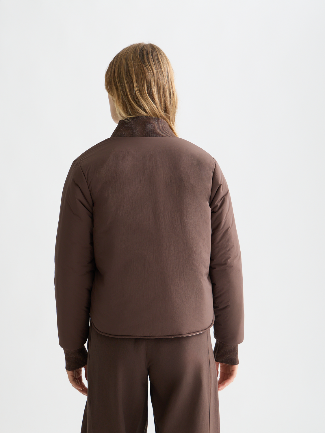 Reversible bomber jacket by Scotch & Soda showing a stylish black and patterned side, displayed from the back.