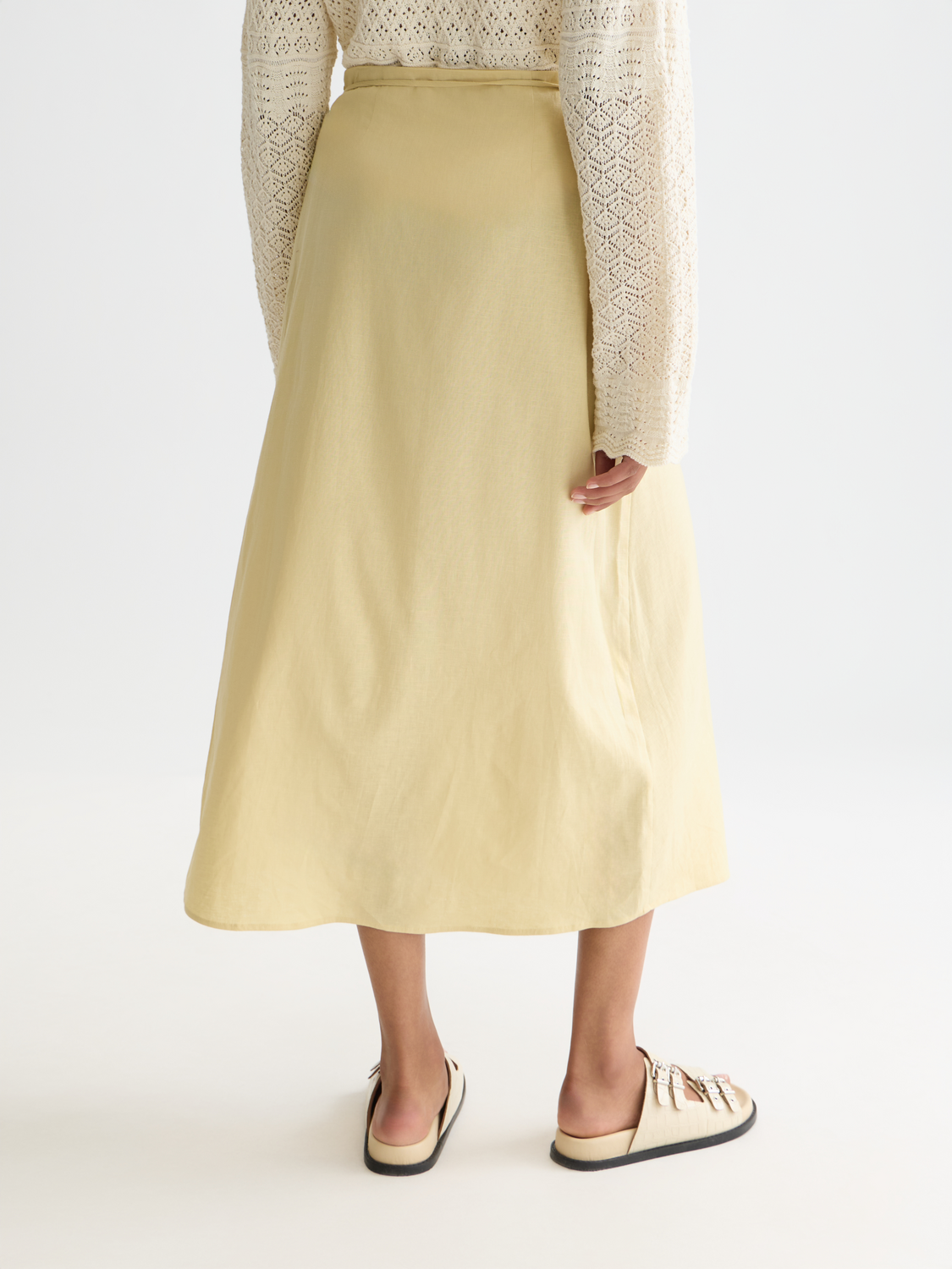 Linen wrap skirt by Scotch & Soda shown from the back, featuring a tie waist and relaxed fit in natural linen fabric.