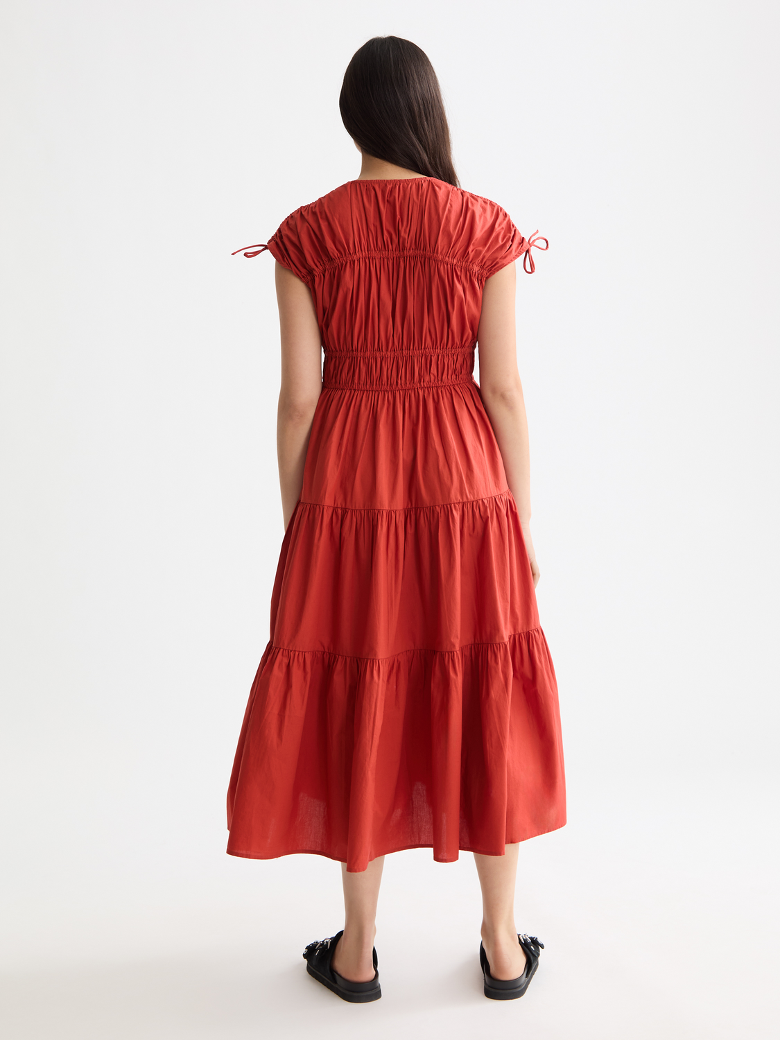 Black gathered midi dress by SCOTCH & SODA featuring a fitted waist and flowing skirt, displayed on a mannequin.