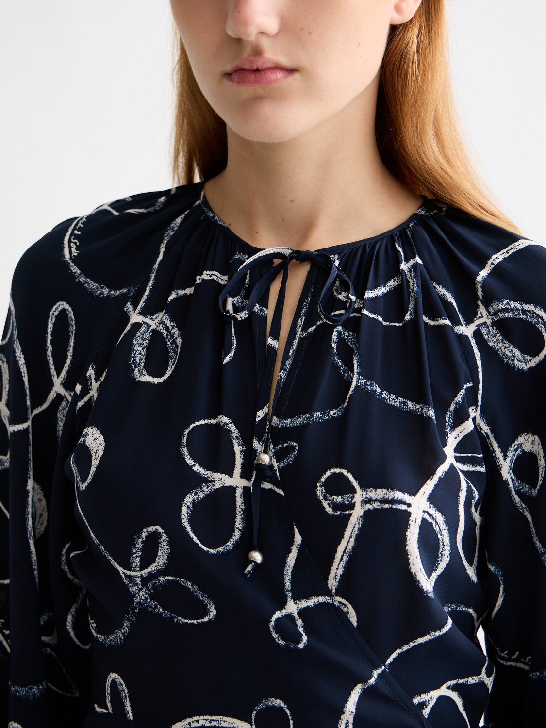 SCOTCH & SODA midi wrap dress in floral fabric, featuring a V-neck and long sleeves, styled on a model.