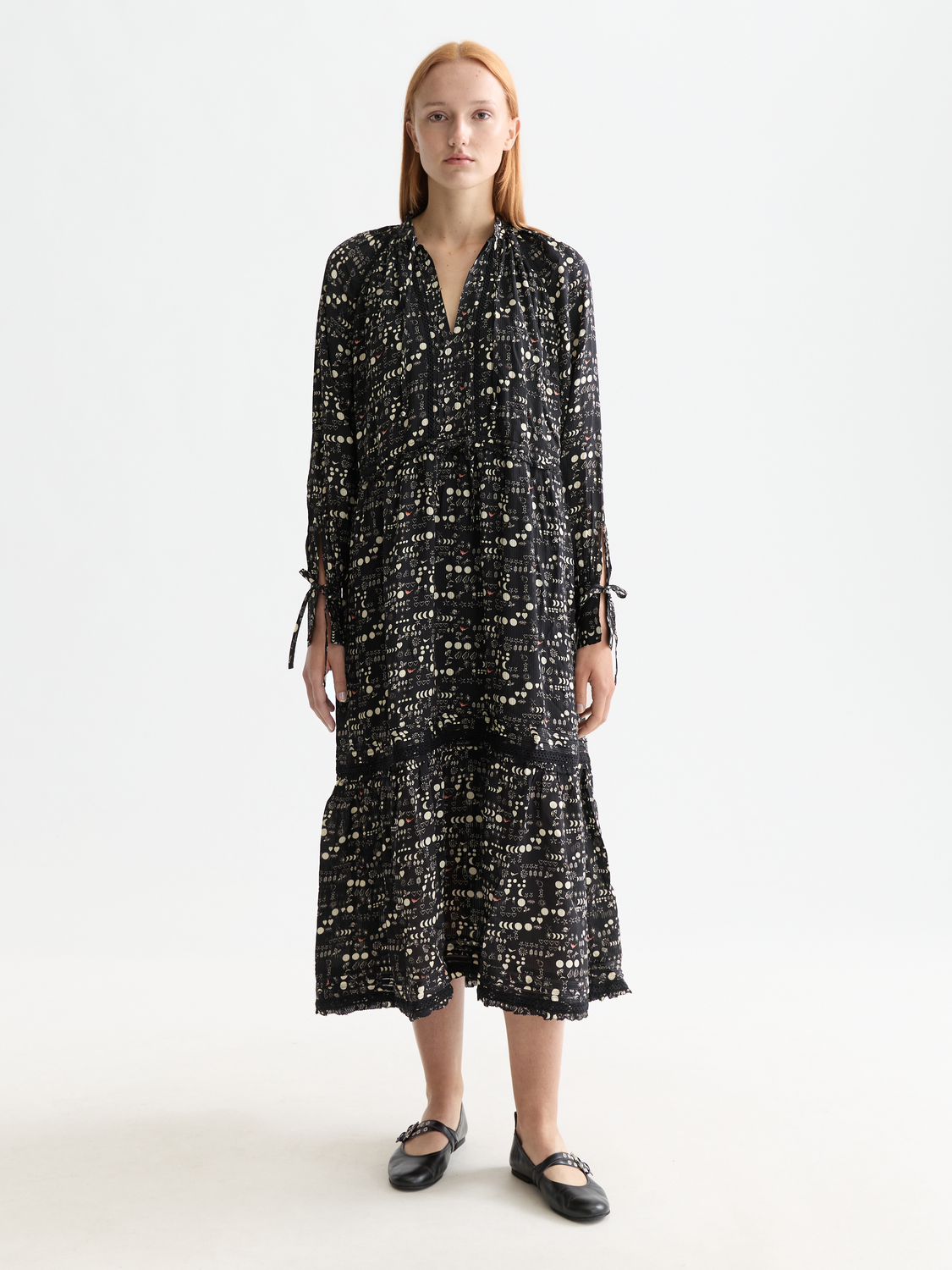 SCOTCH & SODA tiered maxi dress featuring flowing fabric and a vibrant pattern, shown on a model in this fashion image.
