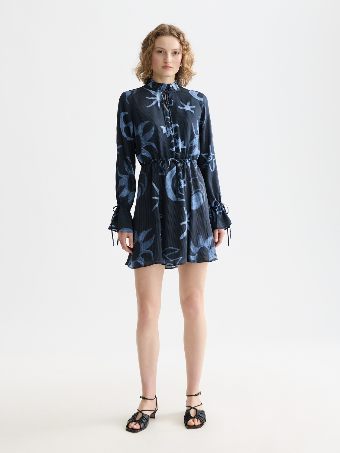 Printed mini dress from Scotch & Soda featuring vibrant floral patterns and a fitted silhouette, shown from the front.