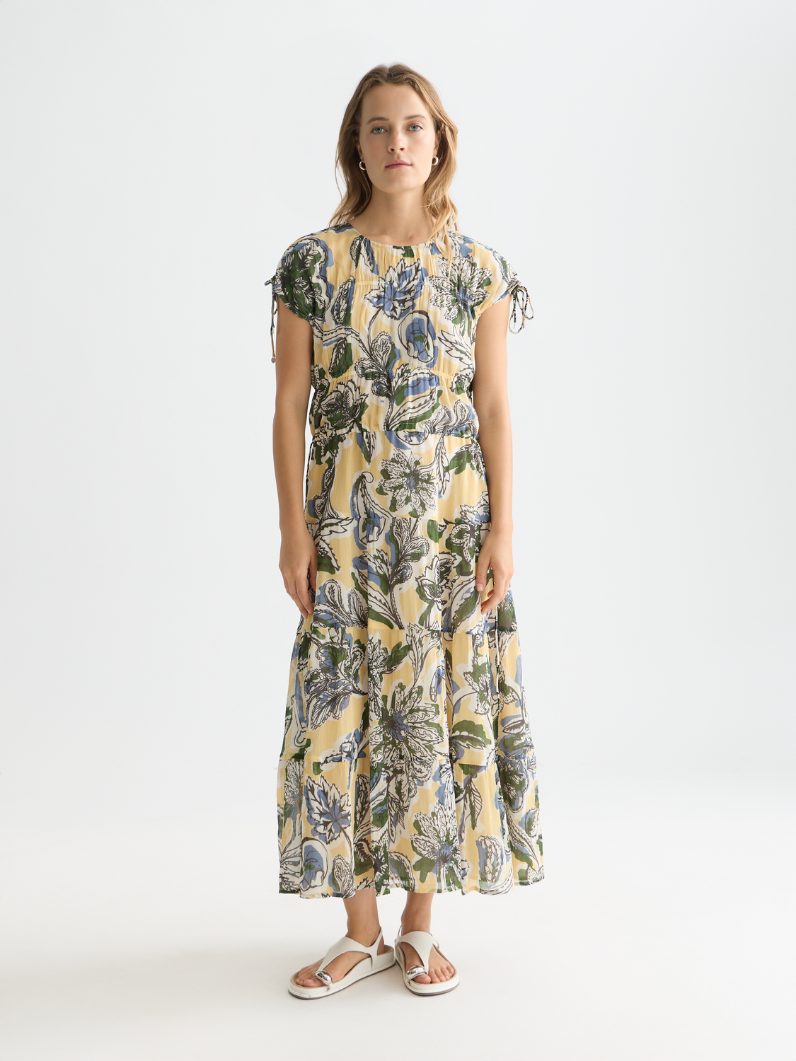 Printed maxi dress by Scotch & Soda featuring a vibrant floral pattern and flowing fabric, styled on a model.