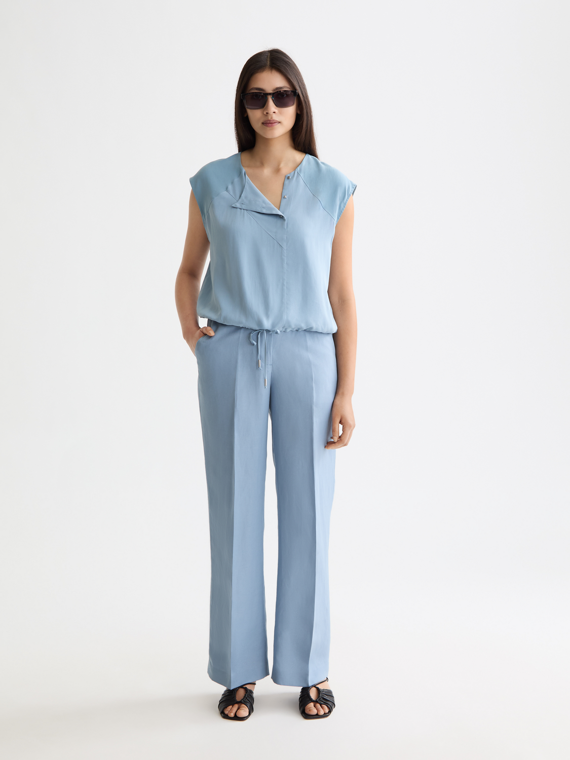 Wide-fit Edie pants by Scotch & Soda featuring a relaxed silhouette and classic design, shown in a neutral fabric.