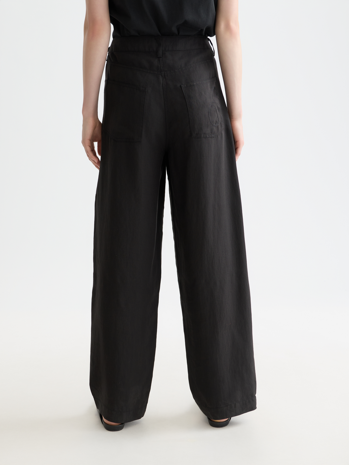 Scotch & Soda Lotus barrel leg pants in dark fabric, back view showing relaxed fit and stylish design details.