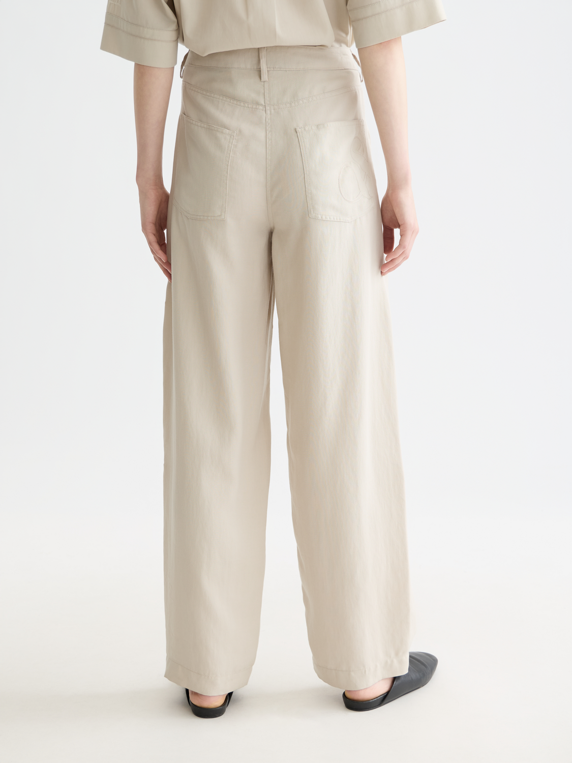 Scotch & Soda Lotus barrel leg pants in dark fabric, showing back view with relaxed fit and stylish design details.