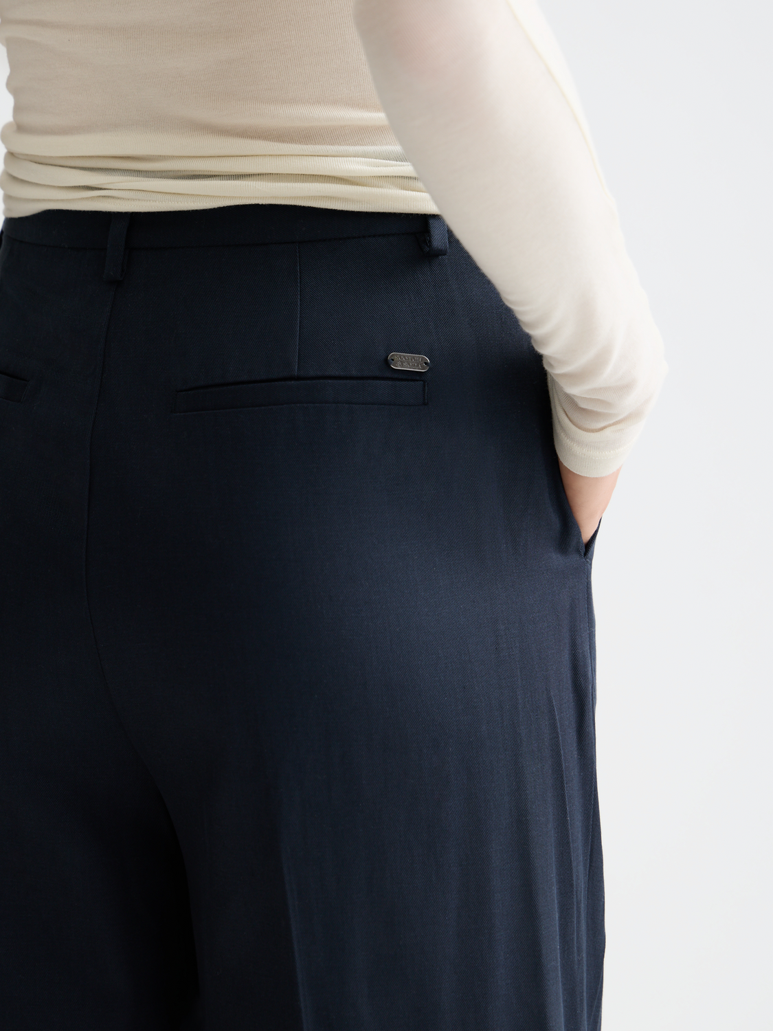 Wide-fit rose-colored pants by Scotch & Soda, featuring a relaxed style and detailed stitching, shown on a model.