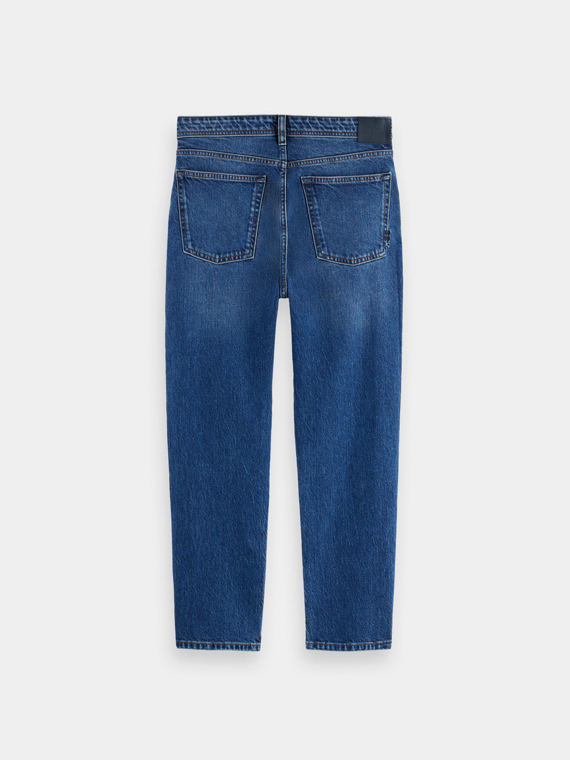 Scotch & Soda Buzz boyfriend-fit denim jeans hanging on a rack with a faded blue wash and relaxed fit style.