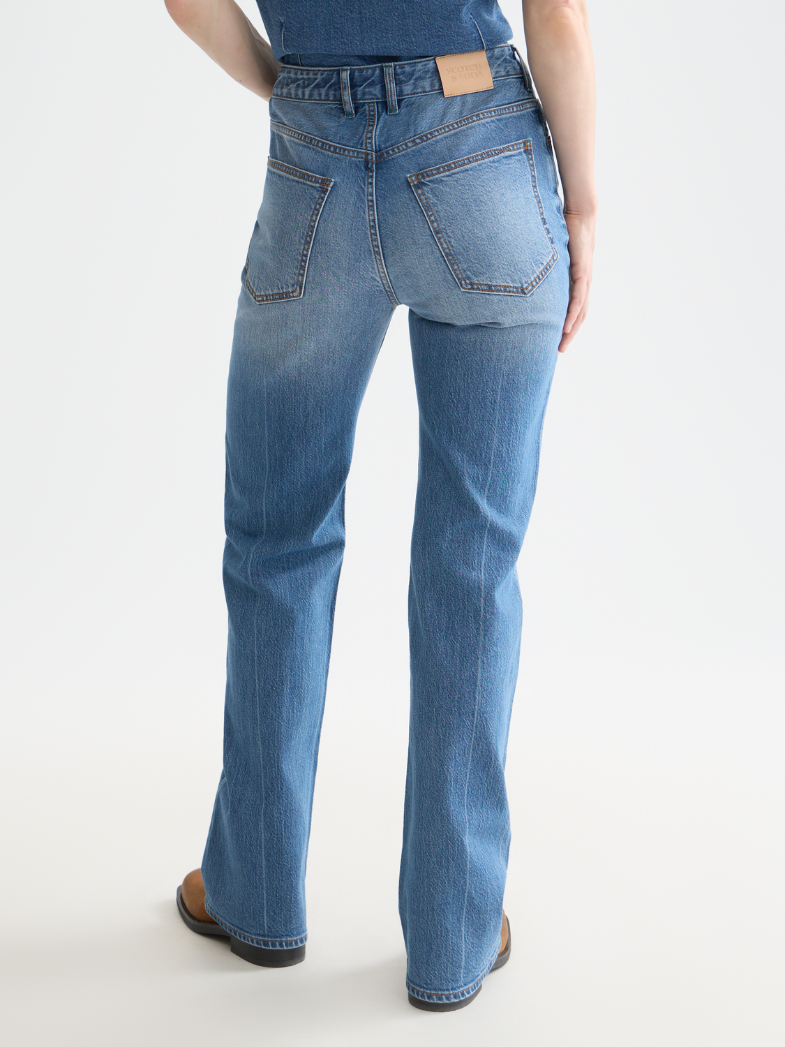 Scotch & Soda glow bootcut denim jeans with back pockets, slim fit design, and stylish fade wash on the denim fabric.