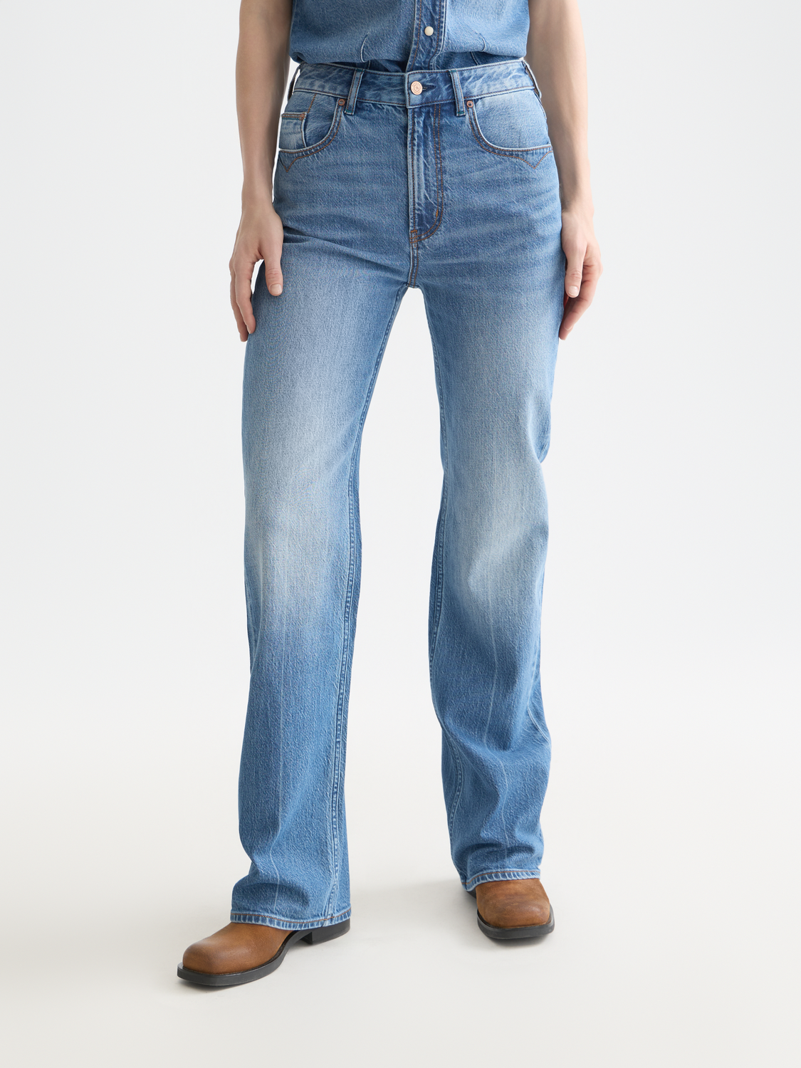 SCOTCH & SODA glow bootcut denim jeans with a fitted waist and flare leg, displayed on a model.