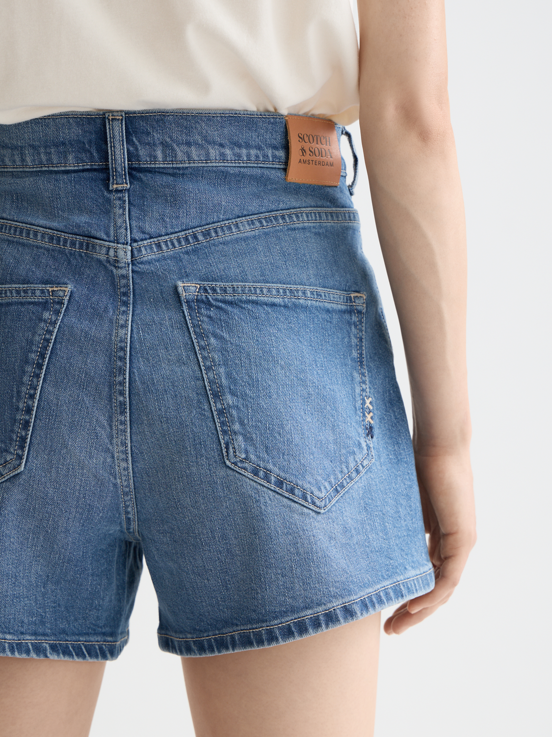 Light blue Ray denim shorts by Scotch & Soda shown on a model, featuring a casual fit and distressed details.
