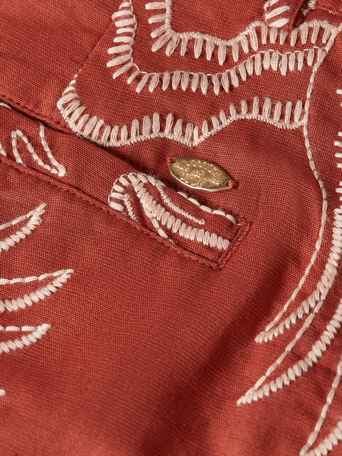 Embroidery detail on stylish Scotch & Soda shorts featuring colorful stitched patterns and a relaxed fit.